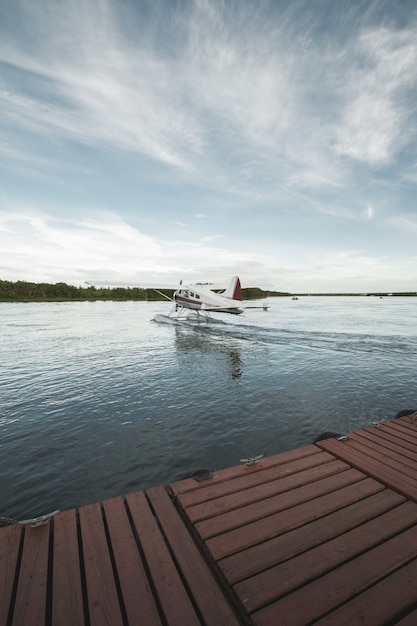 Free Photo vertical shot of a seaplane on the body of a water under clear blue sky