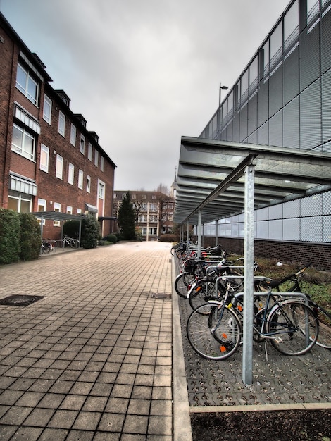 Free photo vertical shot of several bicycles parked next to a building