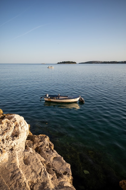 Vertical shot of a small boat on a blue ocean