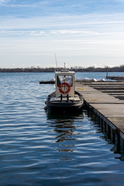 Free Photo vertical shot of a small docked boat during daytime