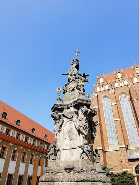 Free photo vertical shot of a statue outside the cathedral of st. john the baptist warsaw, poland