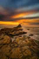 Free photo vertical shot of the stones at the seaside under the fantastic sunrise