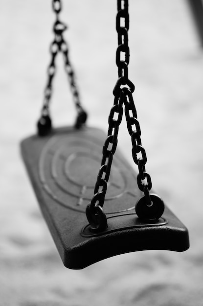 Free photo vertical shot of a swing attached to metal chains