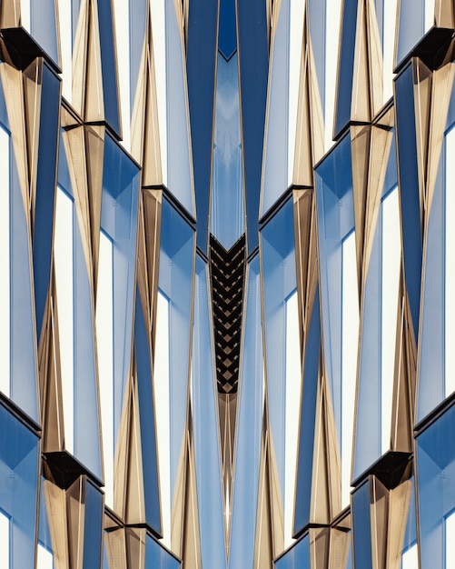 Free photo vertical shot of a symmetrical blue glass and concrete building