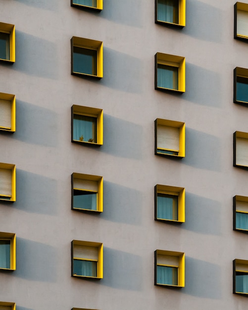 Free photo vertical shot of a white building with black and yellow window frames