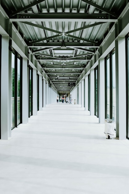 Free Photo vertical shot of a white hallway with glass doors and a metal ceiling in a modern building