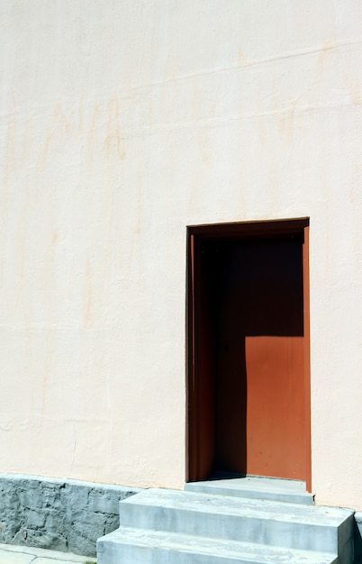 Free photo vertical shot of a white house with a brown door on a sunny day