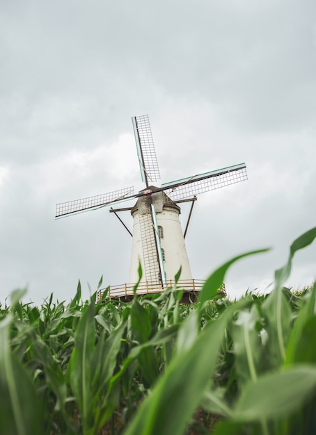 Free photo vertical shot of a windmill with a cloudy gray sky