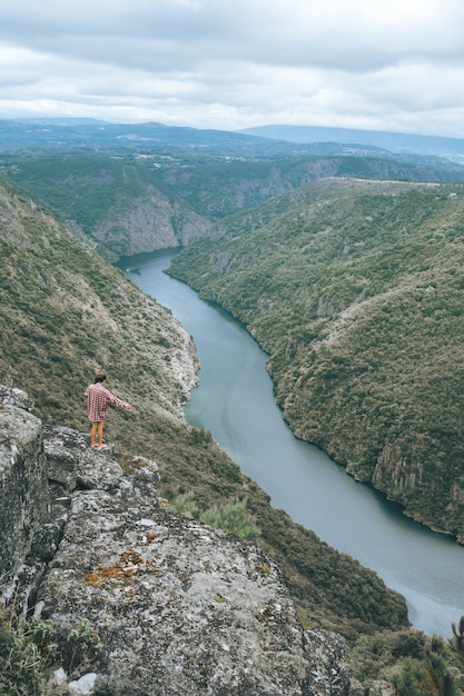 Free Photo vertical shot of a young woman in sil canyon in spain