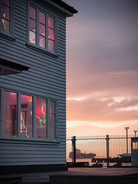 Free photo vertical view of a beautiful wooden house with decorations on the windows near the sea