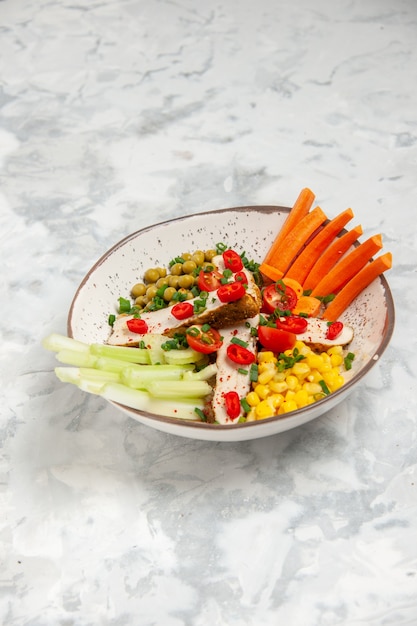 Vertical view of delicious salad with various ingredients on a plate on white surface