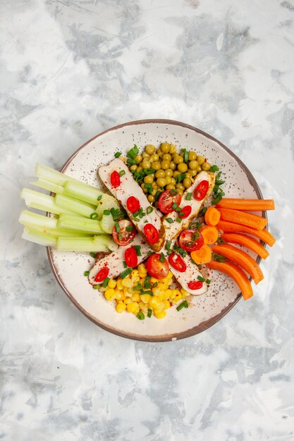 Vertical view of delicious vegan salad on a plate on stained white surface