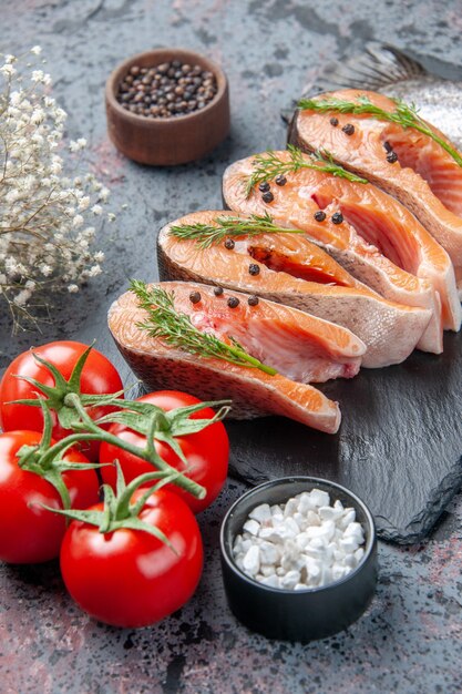 Vertical view of fresh cut raw fishes green on dark color tray spices on blue black mix colors table with free space