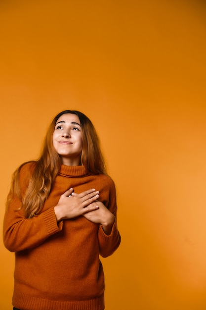 Free Photo vertical view of happily mused redhead attractive caucasian woman dressed in pullover