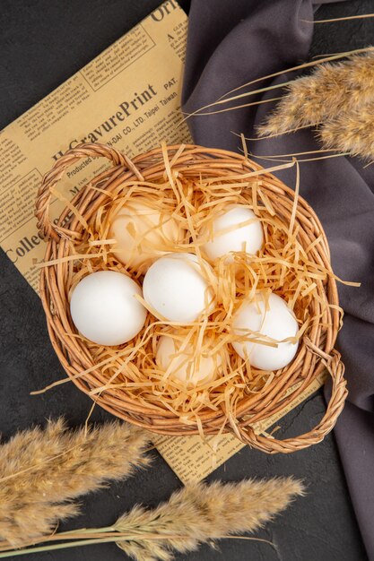 Vertical view of many organic eggs on black towel on dark surface