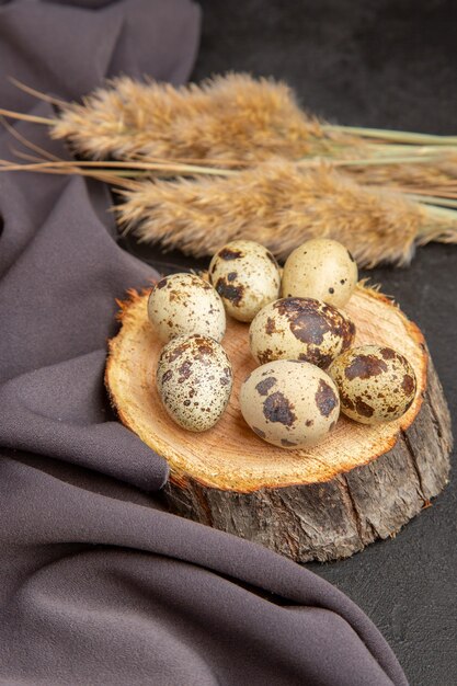 Vertical view of organic eggs on a wooden board spike black towel on dark background