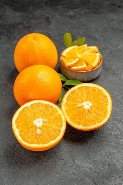 Vertical view of set of yellow whole and cut lemons on dark background