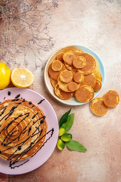 Vertical view of simple and decorated classic pancakes fruits on colourful