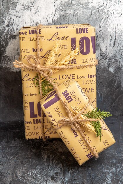 Vertical view of small and big packed gifts standing on wall on dark background