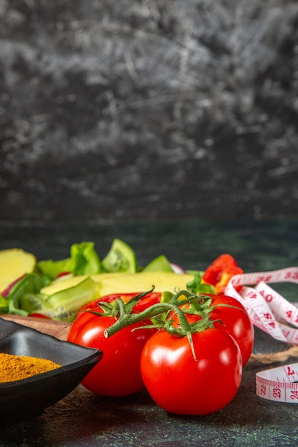 Vertical view of whole cut fresh vegetables and meter spices on mix colors surface with free space