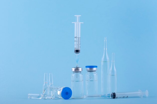 Vials and syringes arrangement with blue background