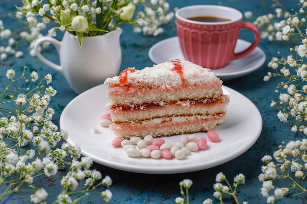 Victoria sponge cake slices with a cup of coffee on light