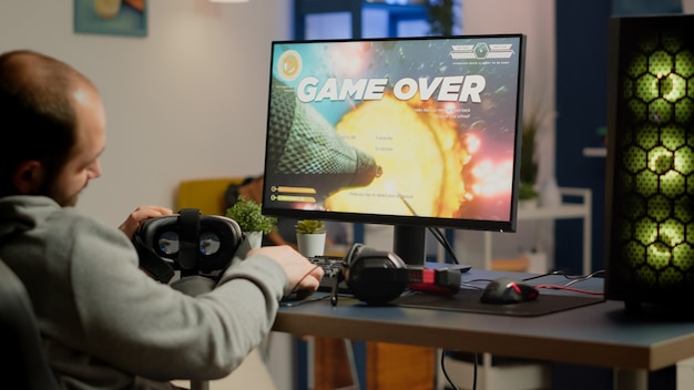 Free photo videogamer losing graphics cyberspace video game sitting on gaming chair using wireless controller and vr headset playing on powerful computer. sad pro cyber man streaming online championship