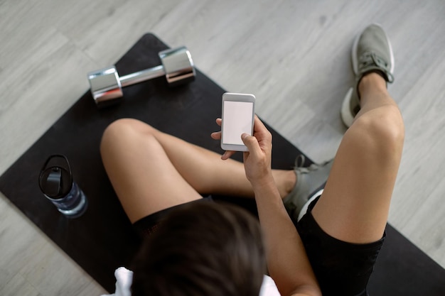 Free photo above view of athlete using cell phone in health club