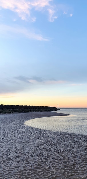 View of the beach in Liverpool at sunset, rows of breakwaters, United Kingdom