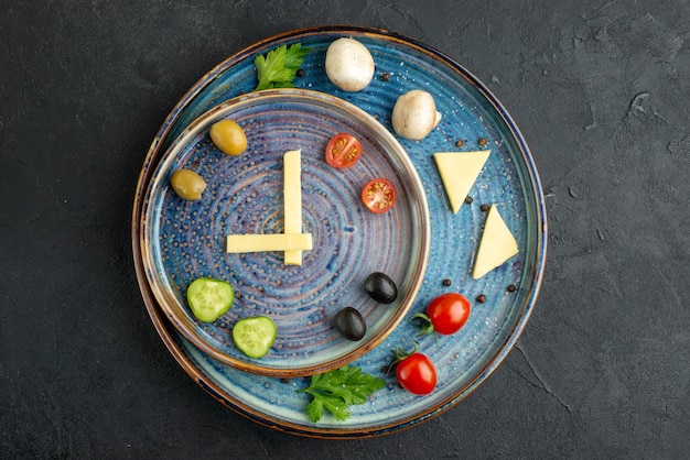 Free photo above view of delicious cheese fresh vegetables on blue trays on black distresed background