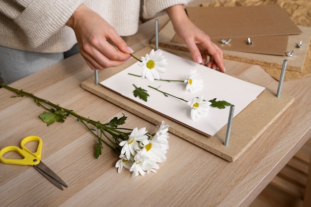 Free photo view of female artisan pressing flowers