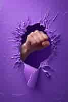 Free photo view of fist ripping through purple surface for women's day celebration