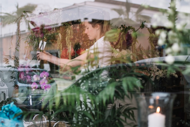 Free photo view of floral shop window with worker