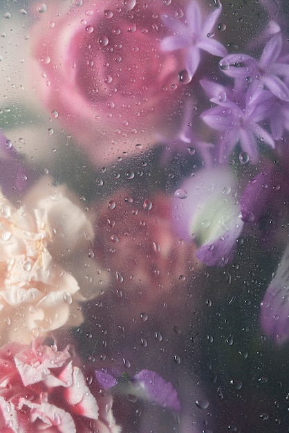 View of flowers through condensed glass