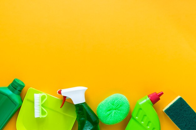 Above view frame with cleaning products on yellow background