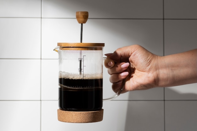 Free photo view of french press for coffee with wooden cup