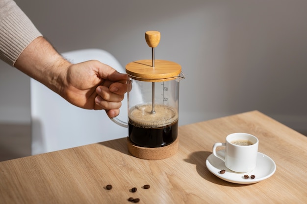 Free photo view of french press for coffee with wooden cup