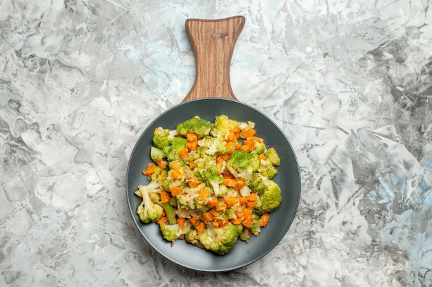 Free photo above view of fresh and healthy vegetable salad on wooden cutting board on white table