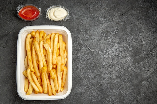 Above view of fried potatoes with sauces