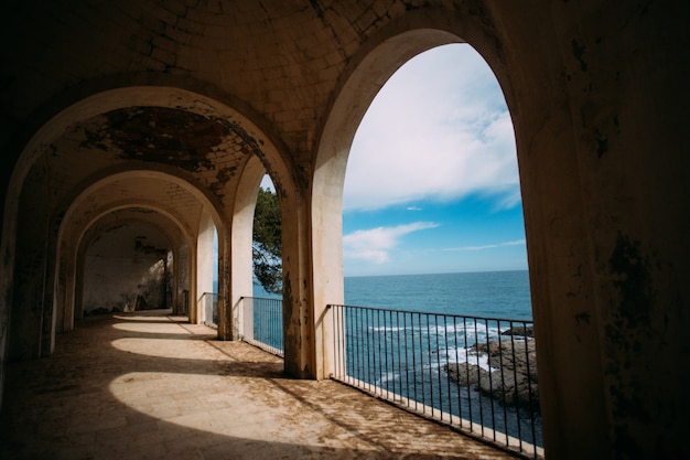 Free Photo view from ancient building on ocean or sea with roman columns and historic ruins on mediterranean coast line.