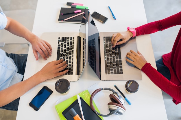 Free photo view from avove on hands of young man and woman working at laptop in co-working office