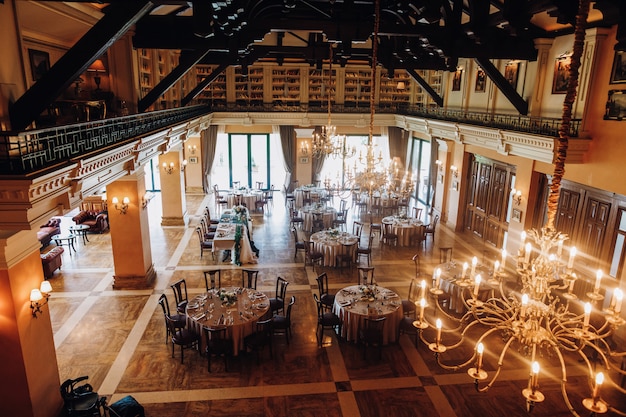 View from the ceiling of decorated celebration hall with round tables