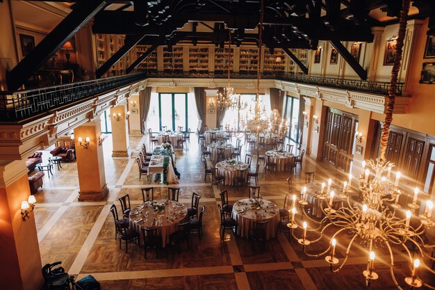 View from the ceiling of decorated celebration hall with round tables