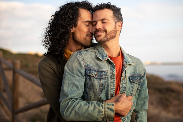 View of gay couple being affectionate and spending time together of the beach