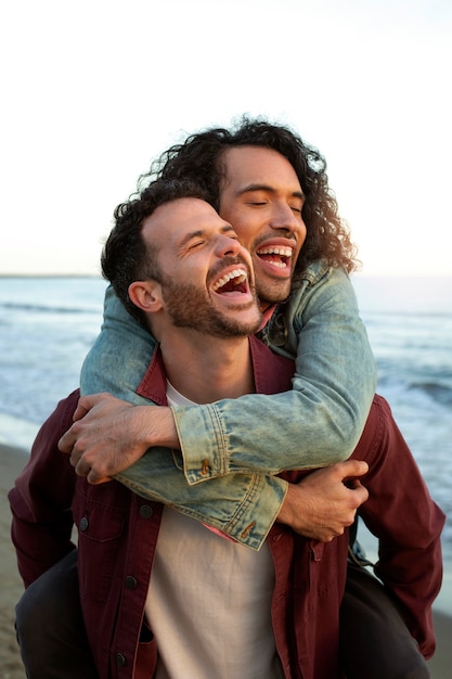 View of gay couple being affectionate and spending time together of the beach