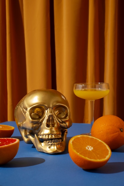 Free photo view of golden skull with citrus cocktail