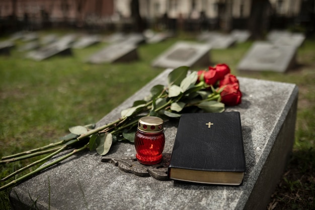 Free photo view of gravestone with flowers and candle