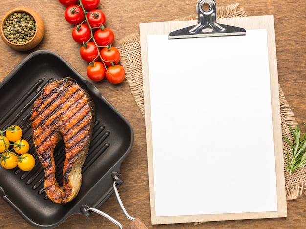 Free photo above view grilled fish with tomatoes