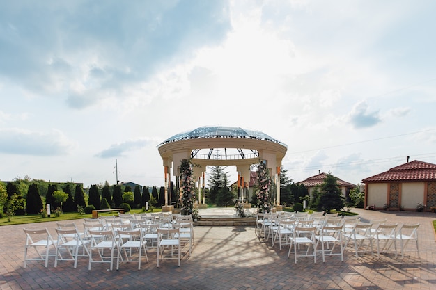 Free photo view of guest seats and ceremonial weddding archway on the sunny say