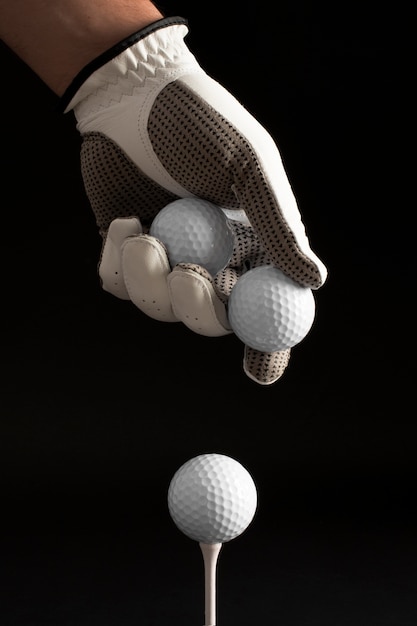 View of hand with glove holding golf balls